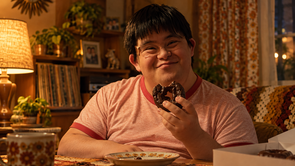 映画『チョコレートドーナツ』で大好きなチョコレートドーナツを手に微笑むマルコ